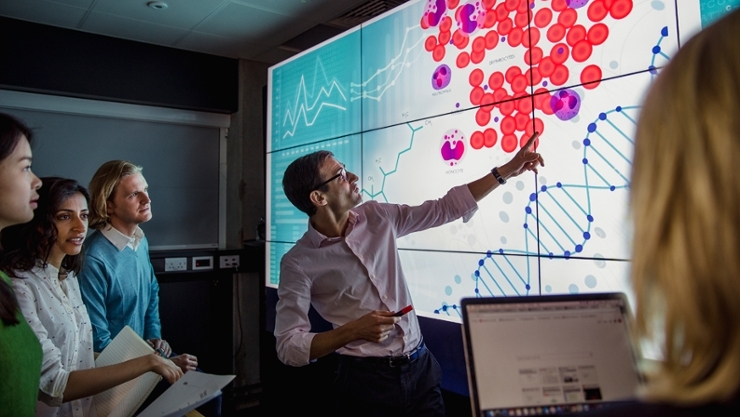 © iStock | SolStock Scientist presenting research results to colleagues